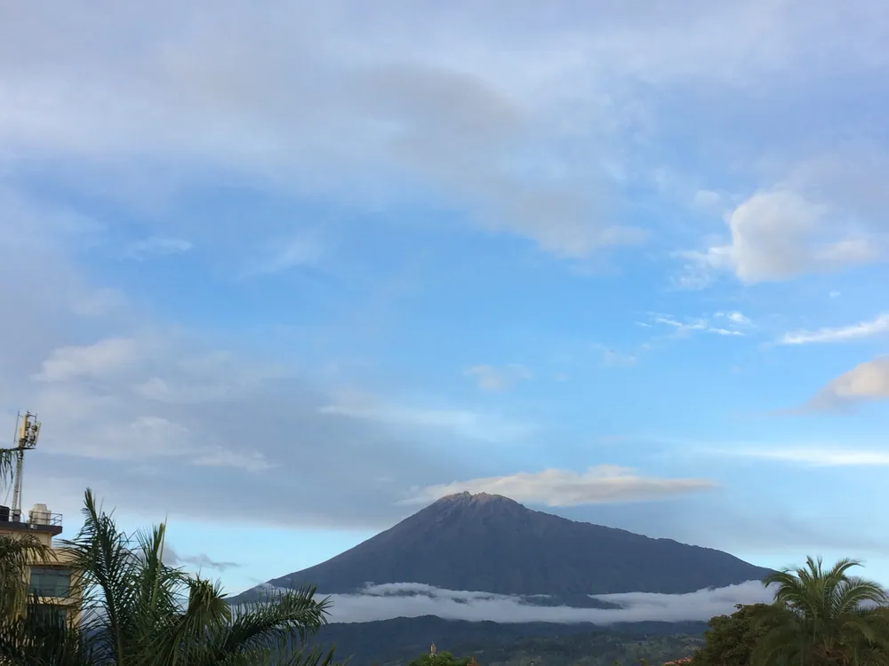 Mount Meru rising behind cloud above the Arusha plains