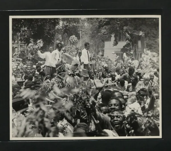 Cheering crowds around a car carrying Julius Nyerere in Dar es Salaam, 1961