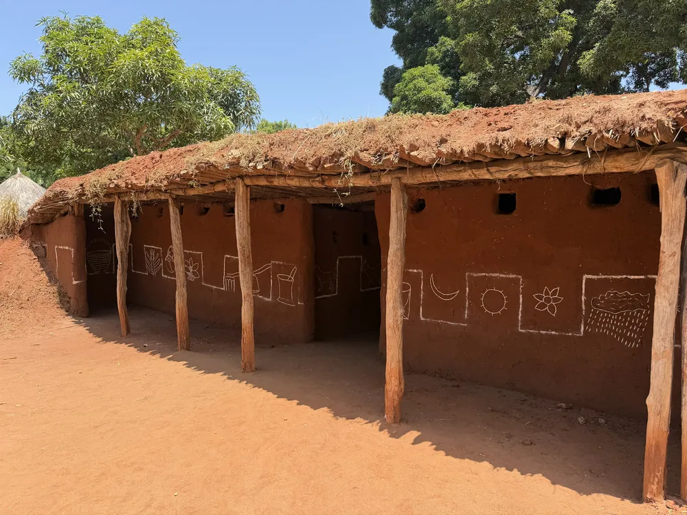 A traditional Iraqw house with earth walls, wooden posts and a flat turf roof