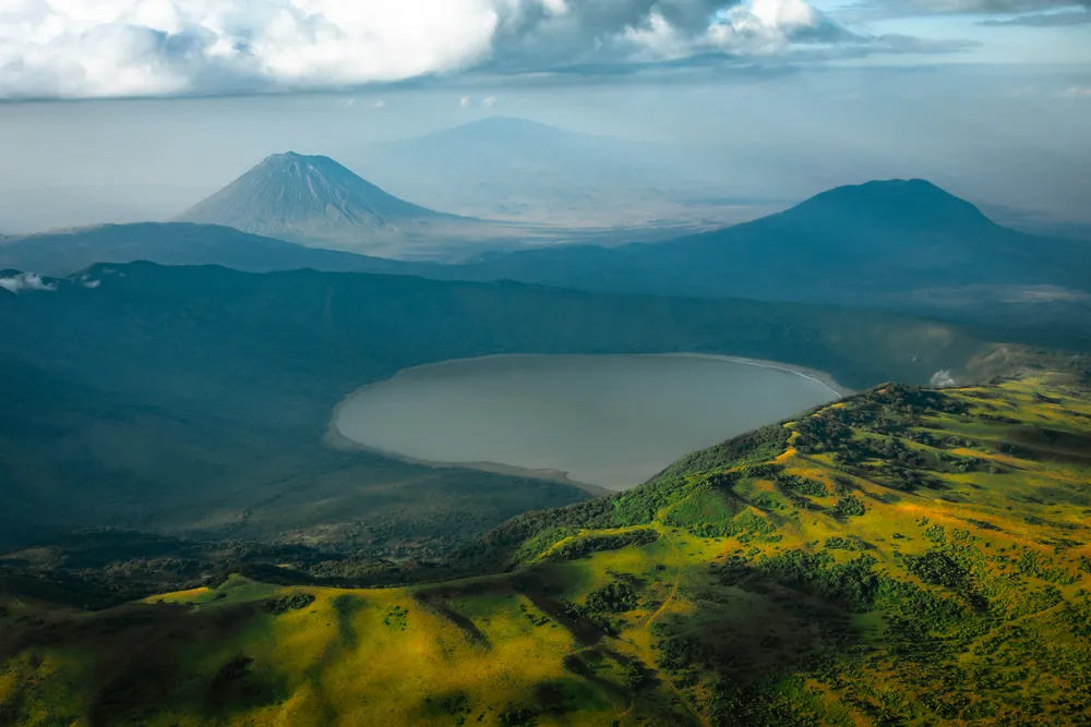 Ol Doinyo Lengai, an active volcano, behind the crater lake of Empakaai in the Ngorongoro highlands. Ash from volcanoes like these buried the fossils.