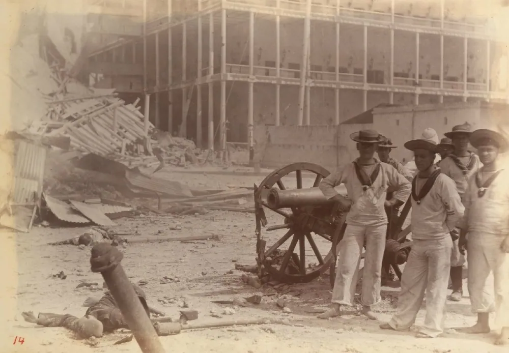 British marines posing with a captured gun among the ruins of the Sultan's palace