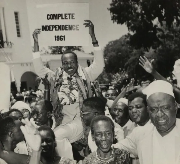 Julius Nyerere holding a sign demanding complete independence in 1961