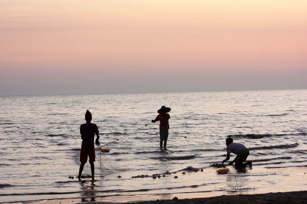 Fishermen with a net in the shallows of Lake Rukwa at dusk